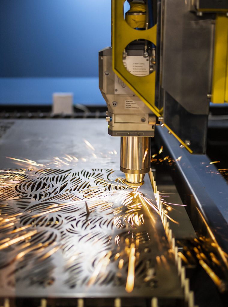 Industrial laser machine cuts out parts in sheet steel.