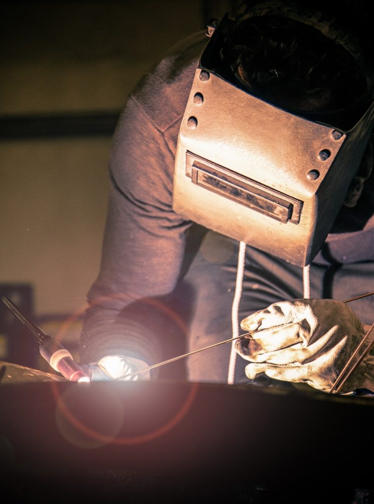 man-in-mask-welding-metal-ware-in-darkness.jpg